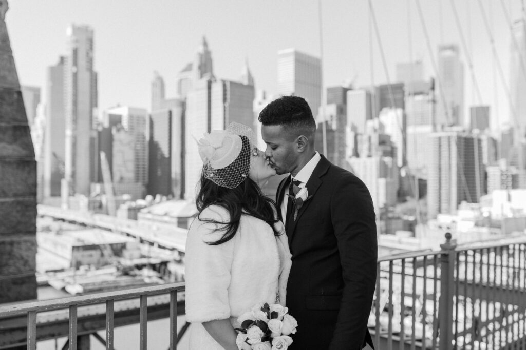 black and white image of couple kissing on brooklyn bridge for their nyc elopement